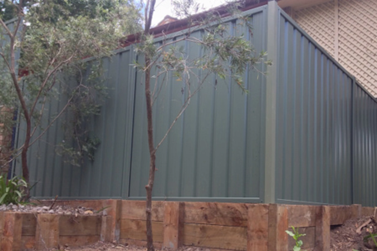 Colorbond steel fence on tiered timber retaining wall